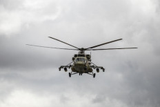A Russian military helicopter monitors the M4 highway by the town of Tal Tamr on May 25, 2020, as Russian and US soldiers prepare to open up the road to civilian traffic between the border towns of Kobane and Tal Tamr for the first time since a Turkish-backed invasion last year saw the route closed.