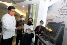 BNI vice president director Anggoro Eko Cahyo (left) talks a customer using a digital BNI account opening service (BNI Sonic) and BNI Mobile Banking application at the BNI Rawamangun branch office in Jakarta on Tuesday.