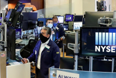 Traders wearing masks work on the first day of in-person trading since the closure during the outbreak of the coronavirus disease (COVID-19) on the floor at the New York Stock Exchange (NYSE) in New York, United States, on May 26, 2020. 