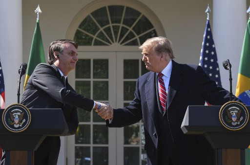 In this file photo taken on March 19, 2019 US President Donald Trump shakes hands with Brazil's President Jair Bolsonaro during a joint press conference in the Rose Garden at the White House in Washington, DC. 