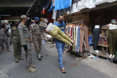 Public Order officers tell traders at Tanah Abang Market to close their stall to adhere to the large-scale social restrictions (PSBB). On Thursday, Jakarta Governor Anies Baswedan decided to extend the PSBB but at the same time ease some of the restrictions.