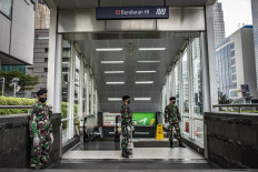 Indonesian Army personnel guard the entrance of Bundaran HI MRT station in Central Jakarta on Wednesday. Starting on Tuesday, military and police officers have been deployed to oversee public compliance with health protocols in 1,800 public facilities in 25 regencies and cities in four provinces as Indonesia plans to embrace a “new normal” to coexist with COVID-19.