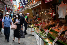 People wearing face masks walk in a street in Tokyo’s Ueno area on May 27, 2020, two days after the Japanese government lifed a nationwide state of emergency. - Japan lifted a nationwide state of emergency over the coronavirus on May 25, gradually reopening the world's third-largest economy as government officials warned caution was still necessary to prevent another wave. 