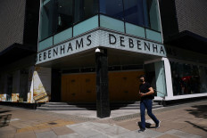 A man wearing a mask walks past Debenhams in Oxford Circus, following the outbreak of the coronavirus disease (COVID-19), London, Britain, May 28, 2020. 