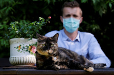 Brian, 24 year-old, suspected to have been infected by the SARS-CoV-2 poses in his garden with Papille, his 9 year-old cat who recovered after being tested positive for the virus amid the coronavirus disease (COVID-19) outbreak, in Athis-Mons, near Paris, France, on May 27, 2020. 