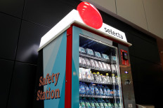 Protective masks are displayed above snacks and drinks at a 'Safety Station' vending machine of Swiss self-service retailer Selecta at the airport in Zurich, Switzerland, on May 28, 2020. 