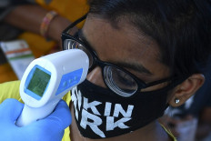 A resident gets her temperature tested at a screening centre set up inside a slum during a nationwide lockdown to fight the spread of the COVID-19 coronavirus, in Mumbai on May 29, 2020.
