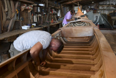 Gondola builders are photographed working on a gondola at the Roberto Dei Rossi boatyard in Venice on May 27, 2020, as the country eases its lockdown within the COVID-19 pandemic caused by the novel coronavirus. 