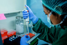 A laboratory staff member works with reagents at the biomolecule laboratory of Warmadewa University in Denpasar, Bali.  JP/Agung Parameswara