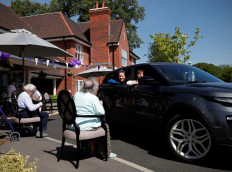 Susan Holding (right) talks with her mother Barbara Webster during a drive-through visit to Gracewell, a residential care home, in Adderbury near Banbury west of London on May 28, 2020. 