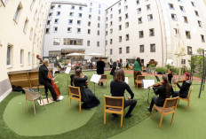 Guests of Zeitgeist Hotel listen from their rooms to singers Monika Medek and Dagmar Dekanovsky and the Camerata Carnutum orchestra, during a window concert (Fensterkonzert) in Vienna on May 30, 2020, as hotels and cultural events have reopened in Austria amid the novel coronavirus pandemic.