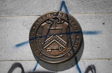 The seal of the US Treasury Department is seen with graffiti on the side of the building next to the White House following riots in Washington, DC on June 1, 2020. - Police fired tear gas outside the White House late Sunday 
as anti-racism protestors again took to the streets to voice fury at police brutality, and major US cities were put under curfew to suppress rioting.With the Trump 
administration branding instigators of six nights of 
rioting as domestic terrorists, there were more confrontations between protestors and police and fresh outbreaks of looting. Local US leaders appealed to citizens to give constructive outlet to their rage over the death of an unarmed black man in Minneapolis, while night-time curfews were imposed in cities including Washington, Los Angeles and Houston. AFP/ Mandel Ngan