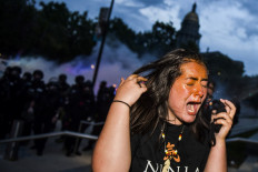 A woman reacts after being sprayed by pepper spray next to the Colorado State Capitol as protests against the death of George Floyd continue for a third night on May 30, 2020 in Denver, Colorado. The city of Denver enacted a curfew for Saturday and Sunday nights and Governor Jared Polis activated the Colorado National Guard in hopes of stopping protests that have wreaked havoc across the city.   AFP/ Getty Images/ Michael Ciaglo
