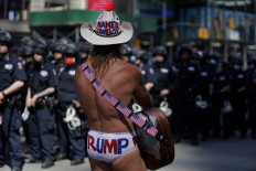 Local street performer Robert John Burck, better known as the Naked Cowboy, looks on at NYPD and protestors in Times Square on June 1, 2020, during a "Black Lives Matter" protest. - New York's mayor Bill de Blasio today declared a city curfew from 11:00 pm to 5:00 am, as sometimes 
violent anti-racism protests roil communities nationwide. Saying that "we support peaceful protest," De Blasio tweeted he had made the decision in consultation with the state's governor Andrew Cuomo, following the lead of many large US cities that instituted curfews in a bid to clamp down on violence and looting. AFP/Timothy A Clary