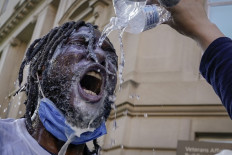 A demonstrator is doused with water and milk after being hit with pepper spray from law enforcement during a protest on June 1, 2020 in downtown Washington, DC. Protests and riots continue in cities across America following the death of George Floyd, who died after being restrained by Minneapolis police officer Derek Chauvin. Chauvin, 44, was charged last Friday with third-degree murder and second-degree manslaughter. AFP/Getty Images/Drew Angerer