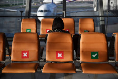 A passenger sits in socially-distanced seats at the gates in a near-empty Suvarnabhumi International Airport in Bangkok on June 3, 2020, as domestic Thai travel starts to pick up following restrictions to halt the spread of the COVID-19 coronavirus. 