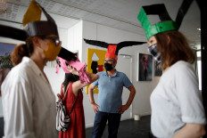 Artists wear colourful 'deconfinement hats' made of paper mache and inspired by Song dynasty headwear, for social distancing, at 59 Rivoli gallery in Paris as it prepares a general reopening later in the week, following the outbreak of the coronavirus disease (COVID-19) in France, June 3, 2020. 
