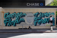 Local artist 'Shawn' paints a mural in memory of for George Floyd, who died in Minneapolis police custody, in downtown Oakland, California, US June 3, 2020. 