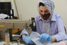 An Egyptian woman makes colourful bedouin-styled face masks on June 3, 2020 at the city of El-Arish, the capital of Egypt's North Sinai province, to be sold online to customers as part of COVID-19 coronavirus prevention. 