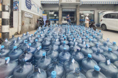 Empty water gallons are seen outside a refilling outlet in this undated photograph in BSD City, South Tangerang, Banten.