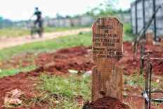 A mockup grave marker advises visitors to follow the COVID-19 health protocols at Jombang public cemetery in South Tangerang, Banten. The cemetery’s workers installed the grave marker after seeing news reports on crowds at airports and shopping centers, despite the physical distancing policy still in force. JP/Seto Wardhana