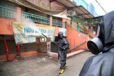 A member of the National Police Mobile Brigade’s chemical, biological and radioactive hazards unit disinfects Cileungsi Market on Monday in Bogor regency, West Java. The market has been closed since May 31, when several traders were found to have contracted COVID-19. JP/P.J.Leo