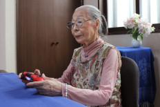 This handout photo taken on May 29, 2020 and received on May 31 courtesy of Keisuke Nagao shows 90-year-old Hamako Mori, dubbed Japan's 'Gamer Grandma', holding a video game controller in Matsudo, Chiba prefecture. 