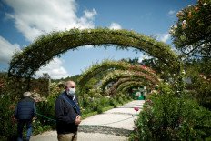 People wearing protective face masks take pictures as they visit the gardens at the reopened Claude Monet house and foundation after restrictions to prevent the spread of the coronavirus disease (COVID-19) were eased, in Giverny, France, on June 9, 2020. 