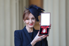 British author J.K. Rowling poses with her medal after being made a Companion of Honour for services to literature and philanthropy by the Britain's Prince William, Duke of Cambridge during an Investiture ceremony at Buckingham Palace in London on December 12, 2017.