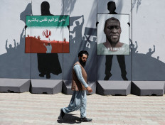 An Afghan man walks past a wall painted with a photo of George Floyd, in Kabul, Afghanistan, on June 10, 2020. 