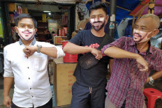 Sellers do elbow bumps at Pasar Lama market in Tangerang, Banten, on June 7. The market requires all sellers and visitors to wear a mask at all times. JP/P.J. Leo