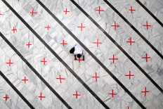 A mosque staff member fixes a physical distancing mark on the floor of the Cut Meutia Mosque in Central Jakarta on Thursday, which had been closed to curb the spread of COVID-19. The city administration has extended large-scale social restrictions but will gradually lift some of the rules, such as allowing houses of worship, shopping centers and offices to open. JP/Seto Wardhana