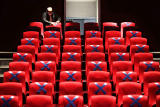 A staff member fixes a physical distancing mark on the seats at the auditorium of the National Library in Jakarta on June 9. JP/Seto Wardhana