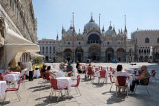 Tourists are seen at the Caffe Quadri at St. Mark's Square a day before Italy and neighbouring EU countries open up borders for the first time since the COVID-19 outbreak hit the country, in Venice, Italy June 14, 2020. 