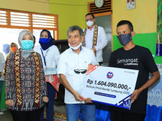Bank BRI president director Sunarso (center) hands out donations valued at Rp 1.6 billion from Yayasan Baitul Mal (YBM) Bank BRI to 31 farmers&rsquo; groups participating in the Peningkatan Keterampilan Usaha Rakyat (PKUR) program, during the &ldquo;Dialog on Food Security Along with UMKM Players&rdquo; event in Balai Desa Bangun Rejo, Lampung Tengah, witnessed by Lampung Deputy Governor Chusnunia Chalim (left) on June 11. As of the end of May, Bank BRI had disbursed more than Rp 1 trillion to the productive sector in Lampung. Of this amount, Rp 605 billion was disbursed to the agricultural sector, Rp 360 billion to animal husbandry and Rp 35 billion to fisheries. Bank BRI distributed Rp 364 billion in KUR in Lampung Tengah.