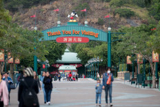 A handful of people walk around the grounds outside the entrance to Hong Kong Disneyland in Hong Kong on January 26, 2020.