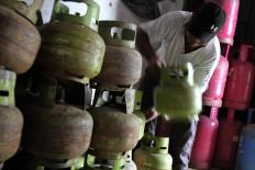 Workers stack empty 3-kg-LPG cylinders at Langgea village in South Konawe, Southeast Sulawesi, on June 15, 2020.