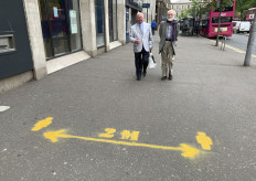 Two men walk in a street with a sign reminding people of the 2-metre social distancing guidlines in Belfast, on June 15, 2020 as some non-essential retailers reopen from their coronavirus shutdown. - Various stores and outdoor attractions in England are set to open Monday for the first time in nearly three months, as the government continues to ease its coronavirus lockdown. 
