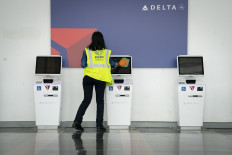  A worker cleans the screens at a Delta self check-in kiosk at Ronald Reagan Washington National Airport, May 5, 2020 in Arlington, Virginia. 