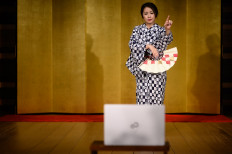 This picture taken on June 13, 2020 shows geisha 'Chacha', who asked to be identified by a pseudonym, dancing during an online drinking party with clients by 'Meet Geisha' in Hakone in Kanagawa Prefecture. 