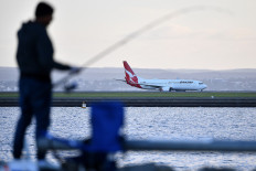 A Qantas Airline plane lands on Sydney International Airport in Sydney on March 27, 2020. 