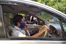 Rules are rules: A military police officer reprimands a driver and his passenger for not wearing face masks on the University of Indonesia overpass in Depok, West Java.