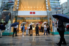 Customers wait in a queue outside a Uniqlo store selling face masks made by Japan's Fast Retailing Co. in Tokyo's Ginza shopping district on June 19, 2020.