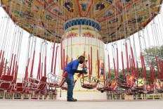A maintenance and cleaning staffer disinfects the chairs of a swing ride at Dunia Fantasi of Ancol Dreamland Park in North Jakarta. The recreation complex has implemented health protocols ahead of its scheduled reopening on June 20, in line with the Jakarta administration’s regulations for the "transition" phase of easing restrictions. JP/Dhoni Setiawan