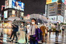 Pedestrians walk with umbrellas as evening rain falls in Tokyo on June 19, 2020.
