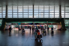AirAsia passengers wearing face masks walk to the check-in counter at the Kuala Lumpur International Airport 2 in Sepang on April 29, 2020. 