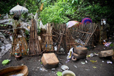 This picture taken on February 20, 2020 shows items (bottom) left from ceremonial offerings for use in the afterlife scattered on the ground next to bamboo cages which cover bodies at a cemetery where Bali's Trunyanese people hold open-air burials - before restrictions were implemented due to the COVID-19 coronavirus - near the village of Trunyan in Bangli Regency, near Lake Batur on Bali island. - For centuries Bali's Trunyanese people have left their dead to decompose in the open air, the bodies placed in bamboo cages until only the skeletons remain -- a ritual they haven't given up -- even as the COVID-19 pandemic upends burial practices worldwide.  AFP/Sonny Tumbelaka