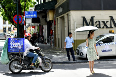 A woman (R) poses for photographs in the middle of a street in Hanoi on June 24, 2020.

