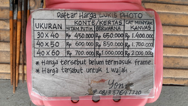 Oil index: A board shows painting service rates at the street gallery of Kota Tua.