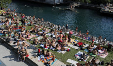 People enjoy hot summer weather on the banks of the Limmat river, as the spread of the coronavirus disease (COVID-19) continues, in Zurich, Switzerland on June 27, 2020. 
